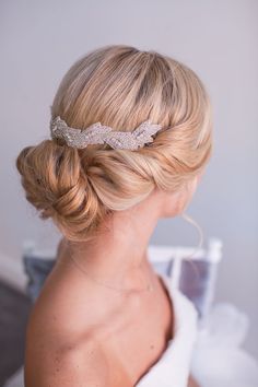 a woman wearing a bridal hair comb with crystal flowers on it's side