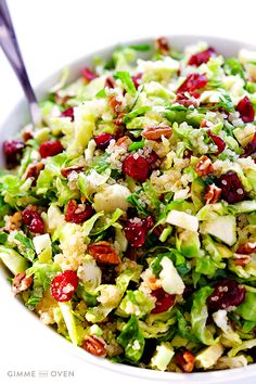 a salad with cranberries, celery and nuts in a white bowl