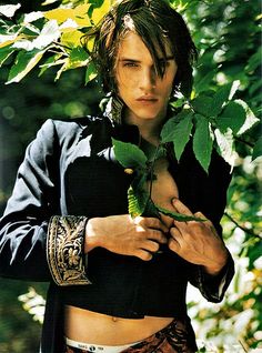 a young man is holding a plant in his hand