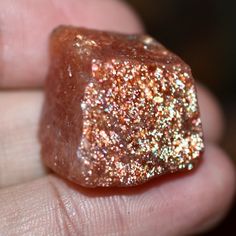 a close up of a person holding a piece of glitter