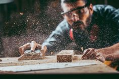 a man is working with wood in his workshop stock - fotografice