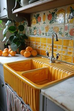 a kitchen sink with oranges on the counter