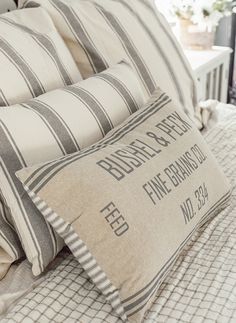 three pillows on top of a bed with white and black striped sheets, one has a pillow that says bubbly space