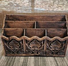 an old wooden box with four compartments on the bottom and one in the middle, sitting on