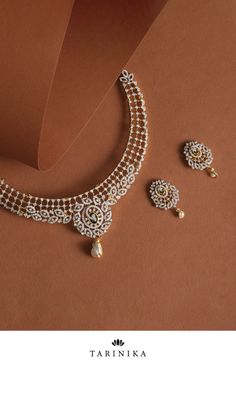 Add a touch of timeless elegance to your look with this exquisite Nakshatra CZ necklace set. Crafted from high-quality CZ stones, and freshwater pearl drops, this jewelry is bold and beautiful. It features intricate ivy and floral motifs that capture the divine beauty of Indian culture. Perfect for special occasions or adding an extra sparkle to your everyday look, this necklace set is sure to make a lasting impression. Elegant Pearl Necklace With Stone Work For Celebration, Elegant Bridal Necklace With Pearl Drop For Diwali, Elegant Necklaces With Stone Setting For Reception, Elegant American Diamond Necklace With Stone Work, Elegant Diamond Chandbali Necklace, Elegant Diamond Necklace With Stone Work For Festivities, Traditional Bridal Necklace With Cubic Zirconia Stones, Elegant Pearl Drop Necklace For Diwali, Elegant Festive Diamond Necklace With Stone Work