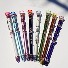 six different colored pens sitting next to each other on top of a white countertop