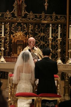 the bride and groom are sitting at the alter