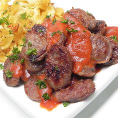 a white plate topped with sausage and pasta