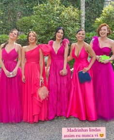 four women in long dresses posing for the camera with one woman wearing a pink dress