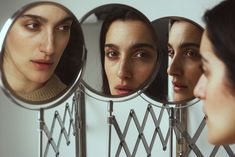 three women looking at their own faces in the mirror