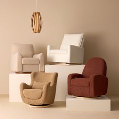 four different colored chairs sitting on white pedestals