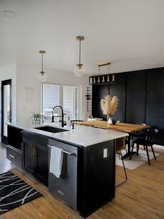 a kitchen with black cabinets and an island in the middle is seen from across the room