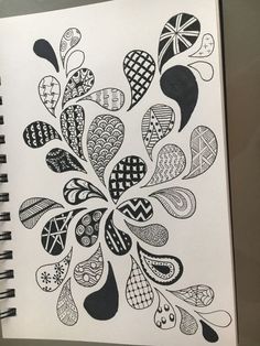 a spiral notebook with black and white designs on it