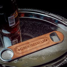 a bottle opener with the name groomsman engraved on it