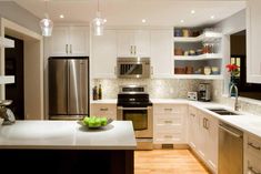 a modern kitchen with stainless steel appliances and white cabinets