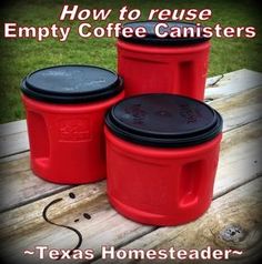 three red and black plastic containers sitting on top of a wooden table next to grass