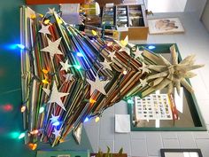 a christmas tree made out of books with lights on the bottom and stars in the middle