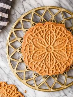 two cookies sitting on top of a gold plate next to a towel and some other items