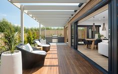 an outdoor living area with wooden floors and white furniture