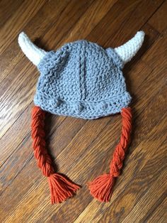 "DACcrochet is the original pattern designer of this item! A grey viking warrior helmet hat with braids has textured raised stitches running down the center front and back, as well as left and right sides to represent \"seams; the bottom band also has raised textured stitches to represent \"rivets\". White horns finish off the viking warrior helmet look. Braids are attached at each side and are available in these colors: orange yellow medium brown dark brown redwood Perfect for a costume, new ba White Horns, Hat With Braids, Viking Hat, Warrior Helmet, Viking Costume, Viking Helmet, Nordic Vikings, Helmet Hat, Colors Orange