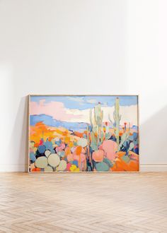 an abstract painting is displayed on the wall in front of a wooden floor and white walls