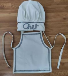 a chef hat and apron on top of a wooden floor