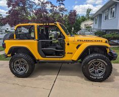 a yellow jeep parked in front of a house