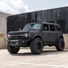 a large black truck parked in front of a building