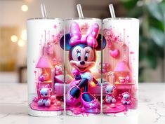 two candles with minnie mouse on them sitting on a table next to a teddy bear