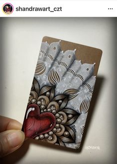 a hand holding up a small card with birds on it