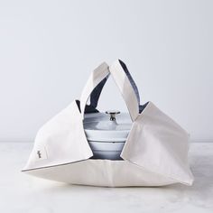 a white tote bag sitting on top of a table next to an empty plate