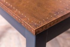 a close up of a wooden table with rivets on the top and bottom