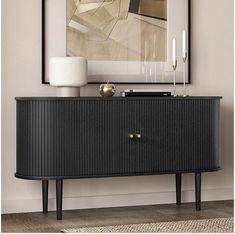 a black and gold sideboard in a living room with a painting on the wall