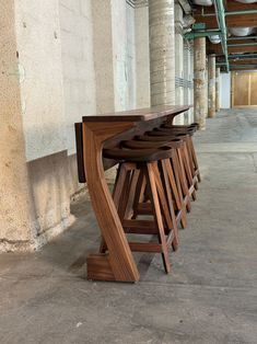 several wooden stools are lined up against the wall