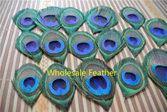 a bunch of peacock feathers sitting on top of a striped tablecloth covered in stripes