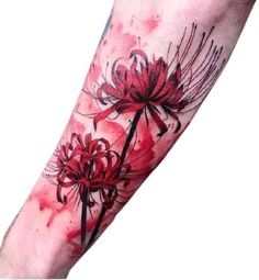 a red flower tattoo on the left forearm and arm with black ink flowers in it