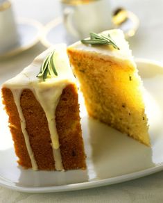 two pieces of cake on a plate with white icing and green sprigs