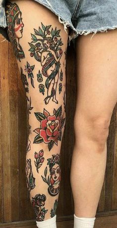 a woman's legs with tattoos on them and flowers all over the leg area