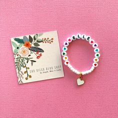 This colorful heart bracelet makes a great birthday gift! The white beads and heart charm make the heart beads pop! Personalize this bracelet for someone you love ❤️ The bracelets are beautifully packaged and ready to gift. Receipts are never included in your package. If you want to include a special note, please let me know in the comments. Roll, don't pull. To avoid excess stretching please roll the bracelet on and off. Treat and store the bracelets gently. Sizing options are just a guideline. Playful Heart-shaped Letter Beads Bracelet, Valentine's Day Heart Charm Bracelet With Letter Beads, Heart-shaped Valentine's Day Charm Bracelet With Letter Beads, Valentine's Day Heart-shaped Charm Bracelet With Letter Beads, Valentine's Day Heart Bracelet With Letter Beads For Friendship, Cute Heart Bracelet With Letter And Round Beads, Cute Heart Bracelet With Letter Beads, Playful Friendship Bracelets With Heart Beads For Gift, Heart-shaped Charm Bracelet With Letter Beads, Gift Idea