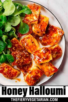 a white plate topped with chicken and spinach covered in marinara sauce next to a green leafy salad