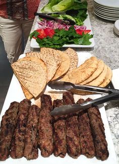 there is a plate full of meat and pita bread on the table with other food items