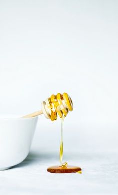 honey being poured into a white bowl