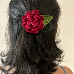 a close up of a woman's hair with a crocheted flower on it