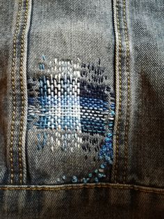 the back side of a pair of jeans with embroidered designs on them, showing stitching