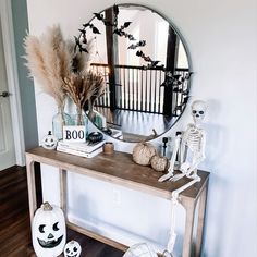 a mirror sitting on top of a wooden table in front of a halloween themed wall