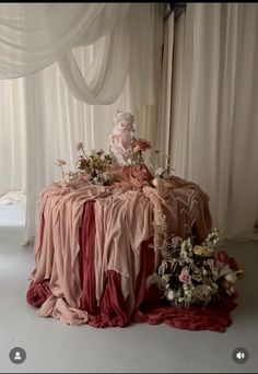 the table is covered in pink and red cloths, with flowers on each side