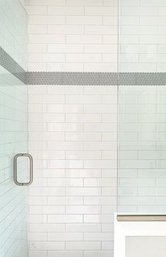 a white tiled bathroom with a walk in shower