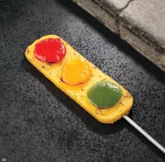 a piece of fruit shaped like a traffic light sitting on top of a black surface