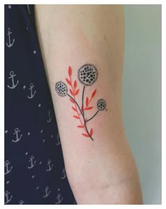 a woman with a red and black flower tattoo on her arm