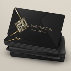 black business card with gold accents and qr code on the front, sitting on top of stacks of black cards